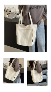 Detailed macro view of large canvas tote bag showing zipper pocket and fashion woven label