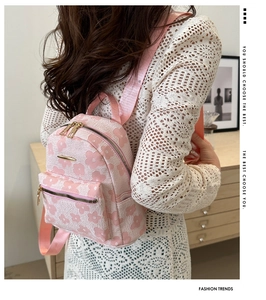 Détail d'un sac à dos jacquard à fleurs roses avec fermetures éclair dorées