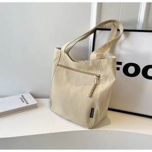 Detail of canvas tote with front zipper pocket and fashion woven label decoration