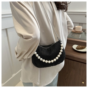 Detail of black rhinestone crescent bag with pearl chain and silver metal strap