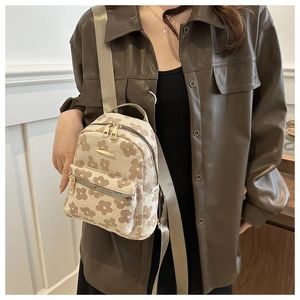 Détails d'un sac à dos en toile florale beige avec des motifs de tournesols doux