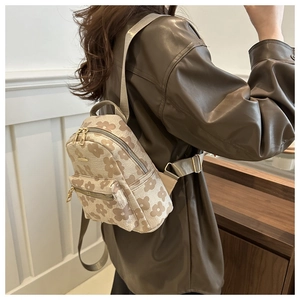 Détail d'un petit sac à dos à motif floral porté par un mannequin en intérieur