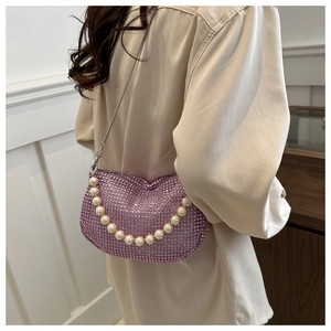 Close-up of pink rhinestone handbag with large pearl strap and metal chain detail
