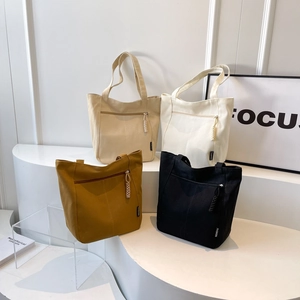Minimalist canvas bucket tote bag in four colors with functional front zipper pockets