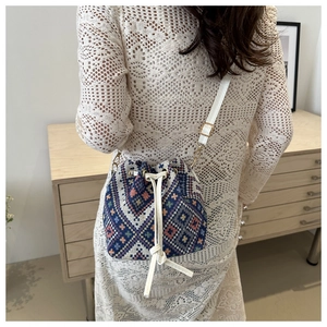 Dettaglio della borsa a secchiello boho con motivi geometrici e coulisse in pelle