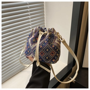 Dettaglio del tessuto geometrico intrecciato e della coulisse in pelle color crema della borsa