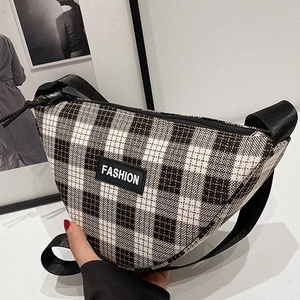 Detail of checkered canvas waist bag with fashion leather patch and adjustable strap
