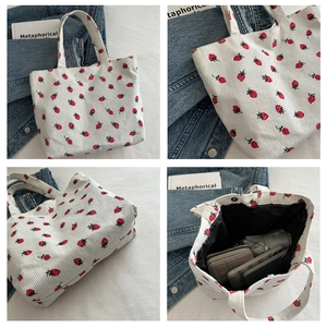Detail view of corduroy tote bag showing large capacity for phone, wallet and umbrella