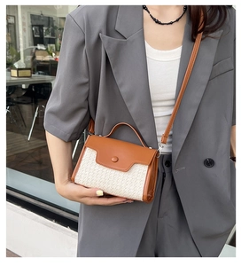 Détail de la texture en tissu tissé et de la bandoulière en cuir marron d'un petit sac