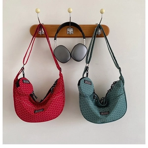Detail of red and green crescent bags with detachable coin purses and adjustable straps