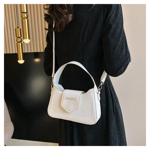 Détail du sac bandoulière en cuir blanc perle avec logo FASHION doré sur le rabat