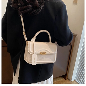 Chic cream white leather crossbody bag with gold twist lock and adjustable strap