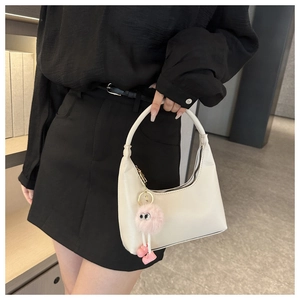 Dettaglio borsa hobo bianca con ciondolo a mostro in peluche rosa e finitura liscia