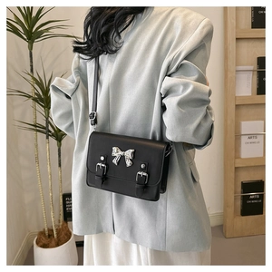 Minimalist black crossbody bag with silver bow buckle and adjustable strap for women