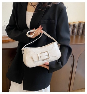 Gros plan du sac bandoulière blanc motif crocodile avec boucle argentée sur un mannequin