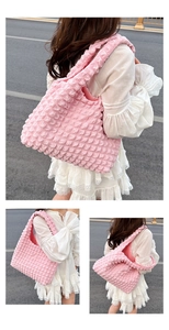 Gros plan d'un sac cabas rose gaufré montrant le tissu plissé porté par un mannequin