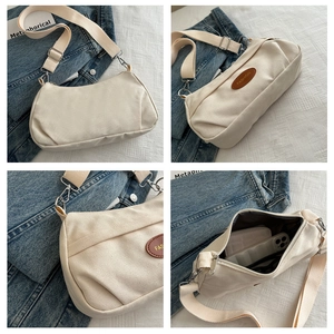 Detail der cremeweißen Canvas-Tasche mit geräumigem Innenraum und Leder-Logo-Patch
