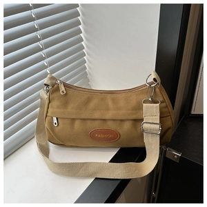 Detail der braunen Segeltuch-Tasche mit Leder-Patch und silbernem Reißverschluss