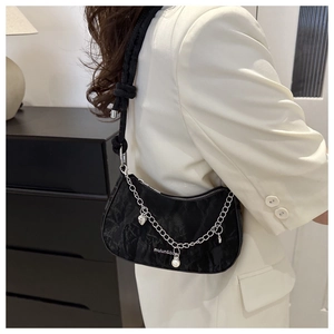 Detail of black crescent shoulder bag with crinkled texture and metallic charms