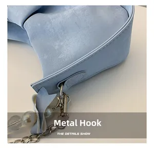 Détail d'un sac bleu clair avec crochet métallique argenté et chaîne décorative en perles