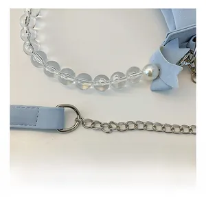 Détail du sac croissant bleu clair avec chaîne en métal argenté et perles acryliques