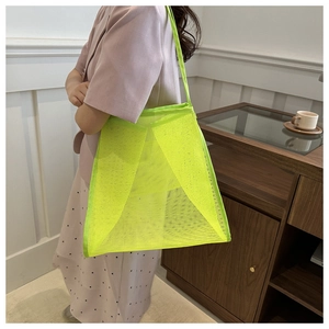 Detalle del bolso tote de malla verde neón con forma geométrica y textura de nailon flexible