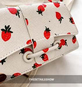 Detail van de aardbeienprint op gebroken wit kunstleer met lychee-structuur