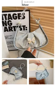 Détail du sac croissant argenté avec grand papillon en métal et anse en perles acryliques