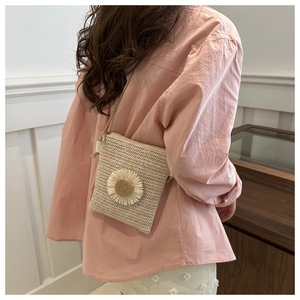 Dettaglio borsa a tracolla intrecciata color crema con margherita e cerniera dorata