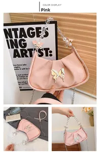 Détail du sac croissant plissé rose avec poignée en perles et breloque papillon métal