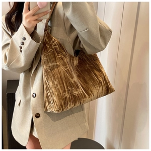 Detailed texture of velvet shoulder bag with bamboo leaf patterns and leather strap