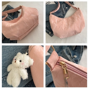 Detalle del bolso hobo rosa con textura arrugada y colgante de osito de peluche