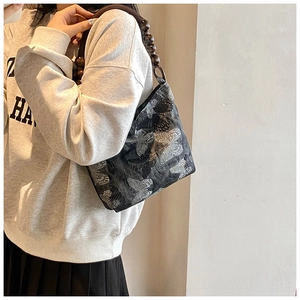 Détail du sac à motif papillon avec poignée en perles de bois foncé vintage