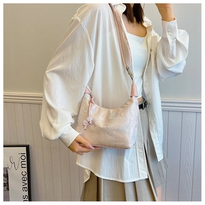 Detail of a floral print hobo bag with tassel drawstring and slender shoulder strap