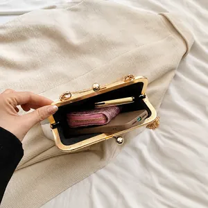 Vue intérieure du sac de soirée blanc avec fermoir doré montrant l'espace pour téléphone