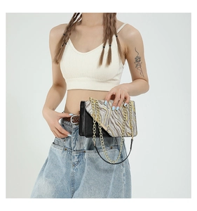 Detail of crossbody bag featuring gold and silver wave sequins with gold chain strap