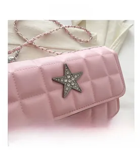 Close-up of pink quilted leather bag featuring a diamond-encrusted silver star buckle