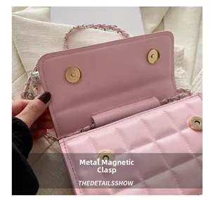 Close-up of the golden magnetic snap and quilted texture on a pink chain crossbody bag