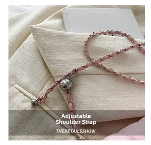 Detailed view of adjustable pink chain strap with silver metal ball buckle on bag