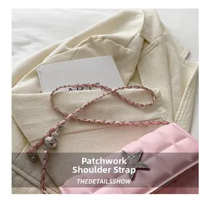 Close-up of pink quilted crossbody bag with star metal clasp and chain strap detail