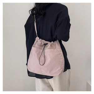 Model mit rosa Kordelzug-Beuteltasche, großen Doppeltaschen vorne und schwarzen Riemen