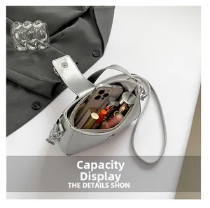 Close-up showing internal capacity of silver crossbody bag with phone and lipstick