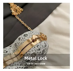 Detail des herzförmigen goldenen Metallverschlusses an einer schimmernden Pailletten-Abendtasche