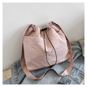 Details der rosa Kordelzug-Beuteltasche mit Nylontextur und funktionalen Fronttaschen