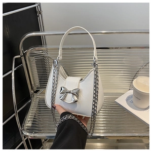 Détail du mini sac à main blanc avec boucle noeud argentée et bandoulière chaîne