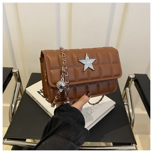 Detail of brown quilted bag with star ornament and silver chain strap for women