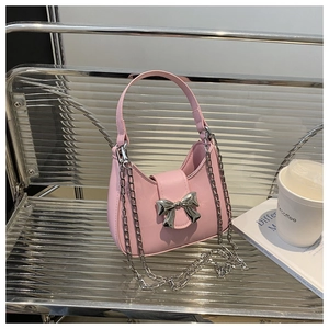 Sac hobo rose avec noeud en métal argenté et bandoulière chaîne sur banc métal