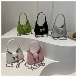 Gros plan de sacs demi-lune stylés avec grandes boucles nœud en métal et chaînes argent