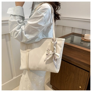 Detalle del asa del bolso tote blanco roto con pañuelo decorativo y textura de cuero PU