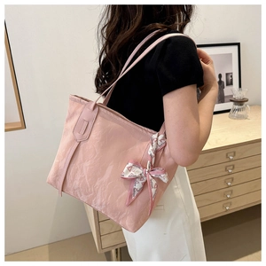 Bolso tote rosa con textura plisada y lazo de cinta de seda decorativo en el hombro